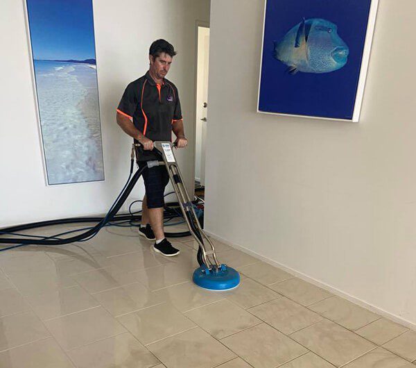 Worker cleaning tile floors — Protect & Sanitise Whitsundays in Proserpine, QLD